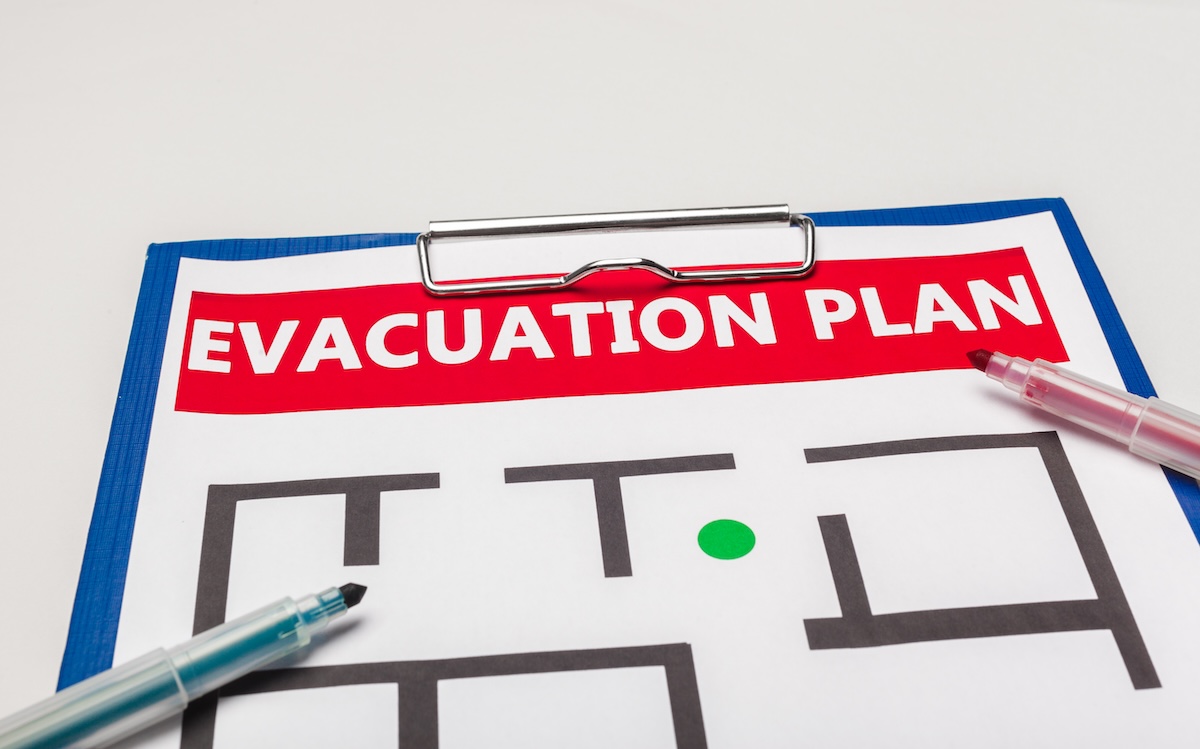 Harta unui plan de evacuare pentru o clădire comercială, afișată pe perete cu indicatoare vizibile.