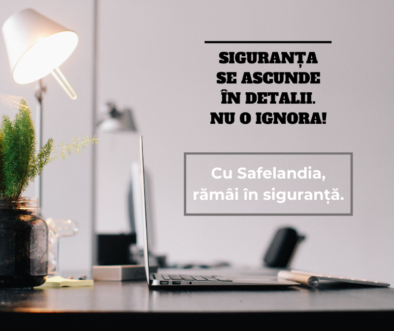 Laptop pe un birou modern, alături de o lampă și o plantă – mesaj despre importanța siguranței la locul de muncă